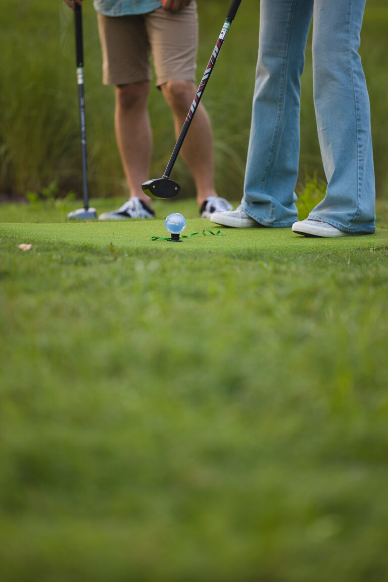 Close-up image of 2 people playing park golf at 1Club.