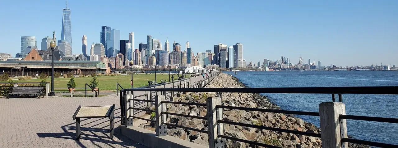 View of Liberty State Park in Jersey City, NJ with open green spaces, walking paths, and the Manhattan skyline in the background