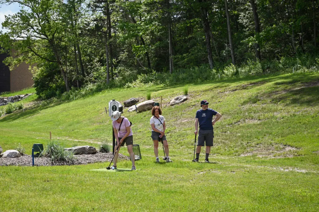 Three people playing park golf at 1Club in Vernon, NJ, enjoying a fun and relaxed game.