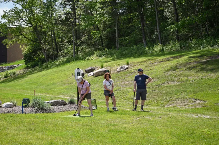 Three people playing park golf at 1Club in Vernon, NJ, enjoying a fun and relaxed game.