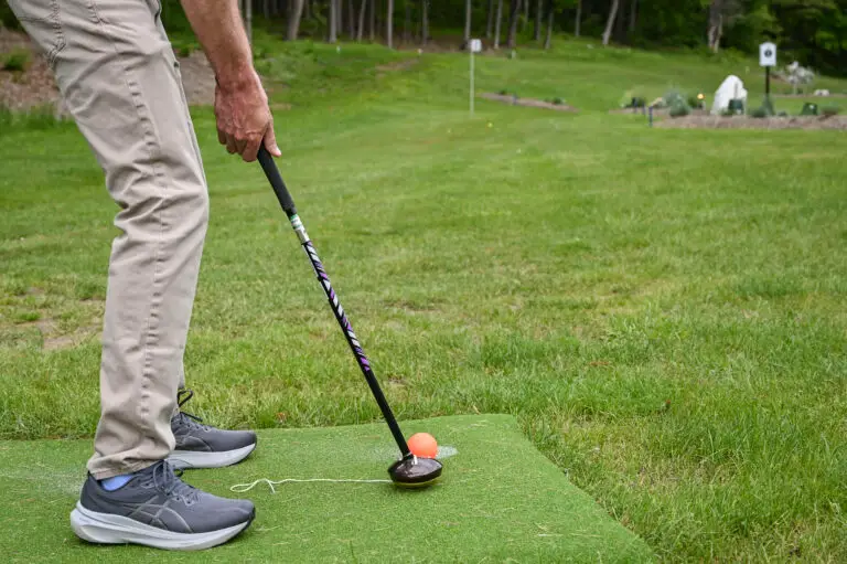 Man playing park golf at 1Club Vernon, surrounded by lush green hills and scenic Vernon Valley landscape under a clear sky, a a symbol of health benefits of park golf.
