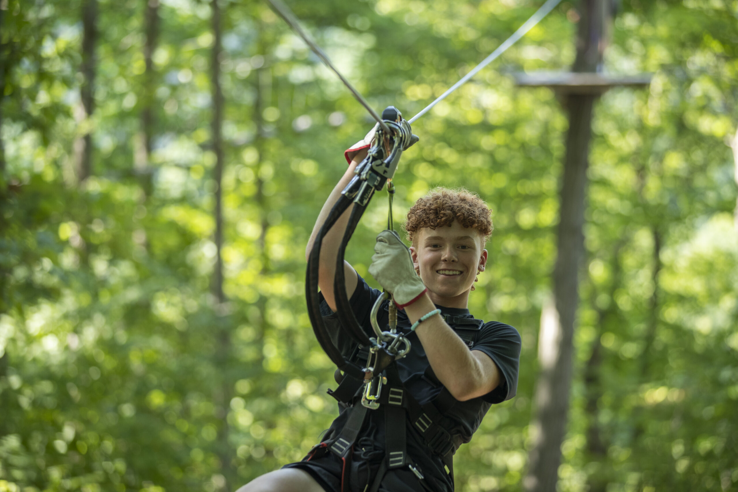 Teenager navigating zip line at TreEscape Aerial Adventure Park, vernon, NJ.