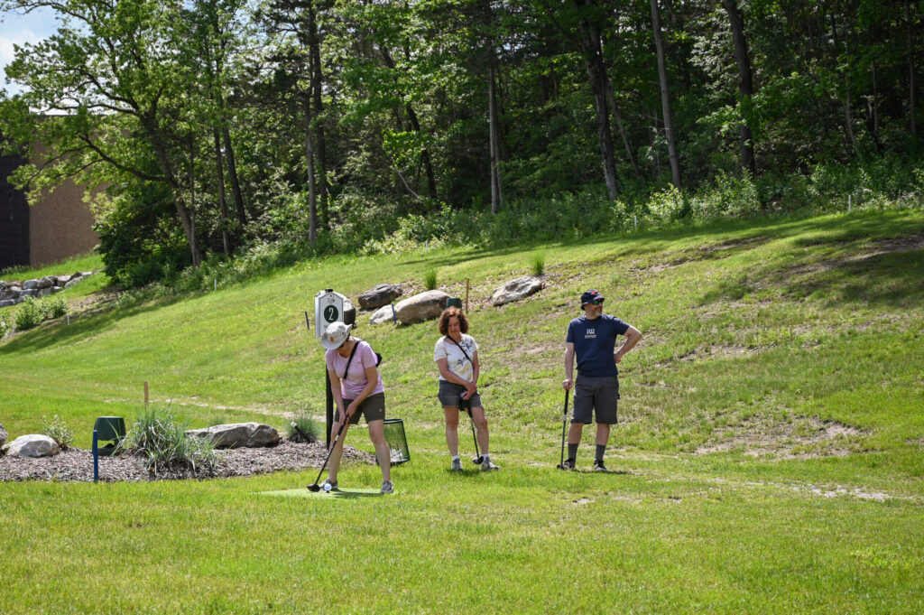 Three people playing park golf at 1Club in Vernon, NJ, enjoying a fun and relaxed game.